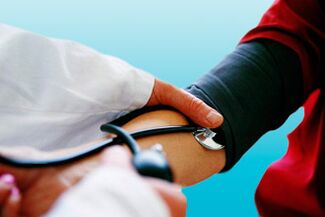 Misurando la pressione sanguigna con un tonometro, un medico può rilevare l’ipertensione in un paziente.